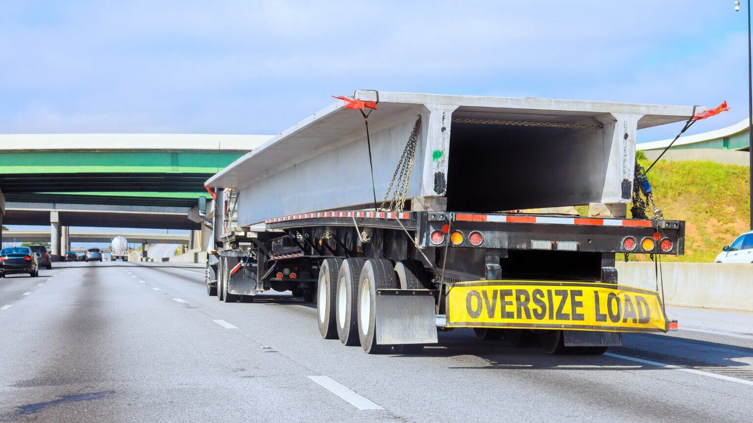 A large flatbed truck carrying oversized cargo on the highway.